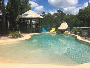 a large swimming pool with a gazebo in a yard at Wondai Colonial Motel in Wondai