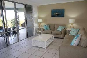 a living room with a couch and a table at Lagoon Beachfront Lodge 005 on Hamilton Island by HamoRent in Hamilton Island