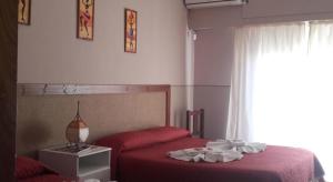 1 dormitorio con 2 camas con sábanas rojas y ventana en Posada La Casona en Salta