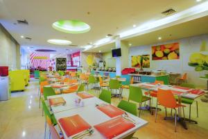 um restaurante com mesas e cadeiras numa cafetaria em d'primahotel Balikpapan em Balikpapan
