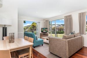 a living room filled with furniture and a large window at Mantra Lorne in Lorne