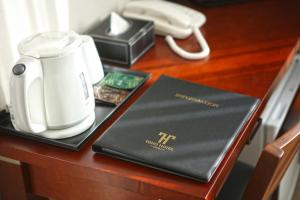 a laptop sitting on a table with a phone and a tea kettle at Toho Hotel in Osaka