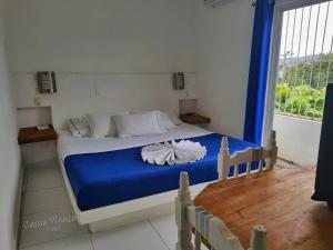a bedroom with a bed with blue sheets and a window at Casssa Vlanca Hotel in Palenque