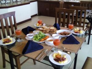a wooden table with plates of food on it at Blackwood Hotel in Haputale