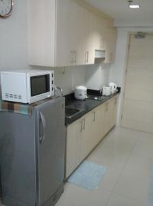 una cucina con un forno a microonde sopra un frigorifero di Sea Residences - Rheiyn a Manila