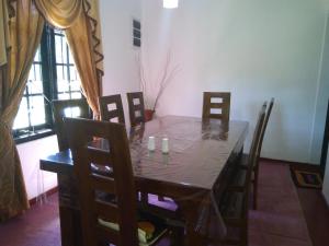 a dining room with a table and chairs and a window at Avon Field Holiday Bungalow in Nuwara Eliya +49 photos