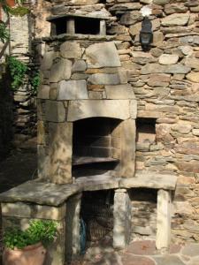 un horno de piedra frente a una pared de piedra en La Bruyère, en Brousse-le-Château