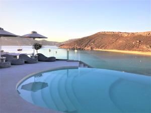 a swimming pool with a view of a body of water at Panormos Village Hotel in Mykonos