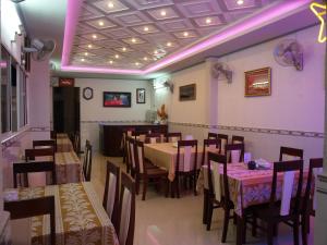 a dining room with tables and chairs and purple lighting at Huynh Lac Can Tho Hotel in Can Tho