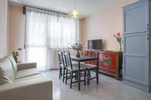 un soggiorno con tavolo, sedie e divano di Appartamento silenzioso in città a Rovigo