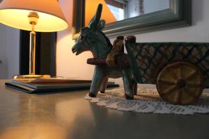 a small figurine of a donkey sitting in a cart on a table at Hotel Miramare in Maiori