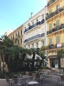 ein Hotel mit Tischen und Stühlen vor einem Gebäude in der Unterkunft Best Place for Palais & Beach in Cannes