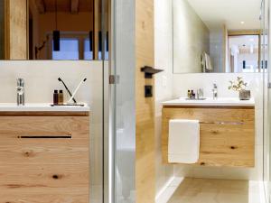 La salle de bains est pourvue d'un lavabo et d'une douche. dans l'établissement EVA Serviced Apartments, à Zermatt