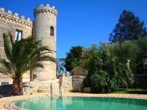 un castillo con piscina frente a un edificio en Rocca Giulia, en Ostuni