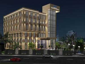 a building with a car parked in front of it at Singhania Sarovar Portico in Raipur