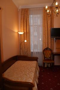 1 dormitorio con cama, lámpara y silla en Nelly Apart en Kiev
