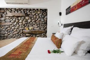 een slaapkamer met een bed met een stenen muur bij Volcanes in Had Nes