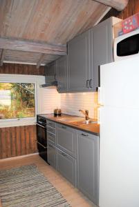 a kitchen with gray cabinets and a white refrigerator at Grindaplassen in Leksvik