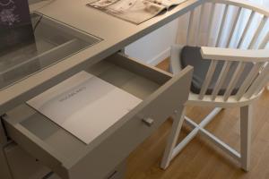 una scrivania con sedia e un cassetto in vetro di Suite Erica Lignano Hotel a Lignano Sabbiadoro