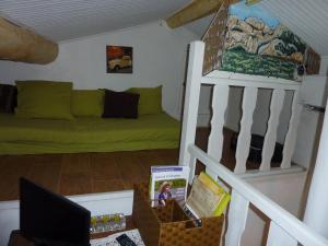 ein Wohnzimmer mit einer grünen Couch und einer Treppe in der Unterkunft Gite Fa Mille maison bleu in Robion en Luberon