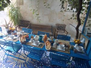 ein Tisch mit blauen Stühlen und Essen darauf in der Unterkunft Gite Fa Mille maison bleu in Robion en Luberon