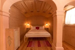 a bed in a small room with a wooden ceiling at Hotel Kaiservilla in Heiligenblut