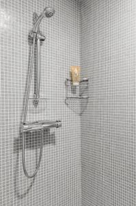 y baño con ducha y pared de azulejos. en Romantic Apartment Prague near Charles Bridge en Praga