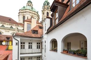 a group of buildings with a clock tower in the background at Romantic Apartment Prague near Charles Bridge in Prague