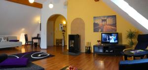 ein Wohnzimmer mit einem Sofa und einem TV in der Unterkunft Cochem Ferienwohnung Scheuer in Cochem