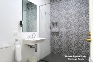a bathroom with a sink and a shower at Tathra Hotel & Motel in Tathra