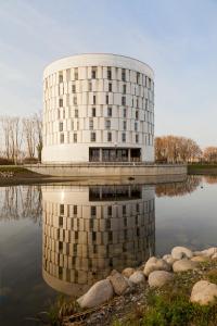 a building with its reflection in a body of water at Mercure Toulouse Sud in Toulouse