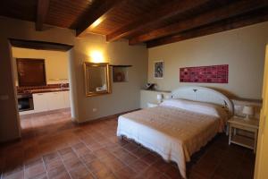 a bedroom with a large bed and a kitchen at Donna Giulia in Caprioli
