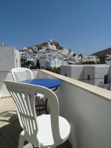 a table and chairs on a balcony with a view of a city at Four Seasons Rooms & Apartments in Ios Chora +16 photos
