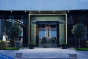 otwarte szklane drzwi budynku z dwoma drzewami w obiekcie Hotel Fashion - Free Parking w mieście Sofia