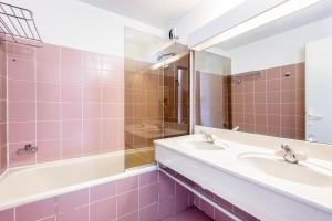 a bathroom with two sinks and a tub and a mirror at Residence Les Bergers - maeva Home in L'Alpe-d'Huez +28 photos