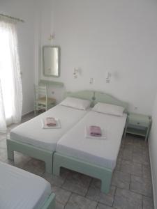 1 dormitorio con 2 camas y espejo en Four Seasons Rooms & Apartments, en Ios Chora