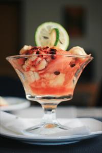 a glass dish with a fruit salad on a plate at Musanto Hotel in Gisenyi +39 photos
