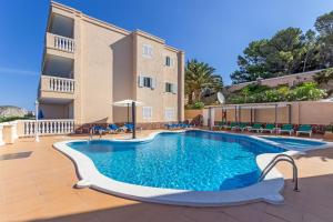 a swimming pool in front of a building at Apartamentos Amores San Telmo in Sant Elm +8 photos