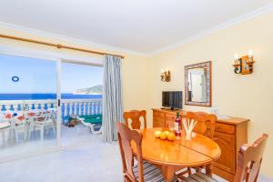 a dining room with a table and a view of the ocean at Apartamentos Amores San Telmo in Sant Elm