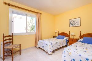 - une chambre avec 2 lits et une fenêtre dans l'établissement Apartamentos Amores San Telmo, à Sant Elm