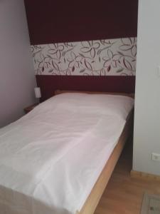 ein Bett mit weißer Bettwäsche und einem braunen Kopfteil in der Unterkunft Ferienwohnung ZENTRAL in Eisenach