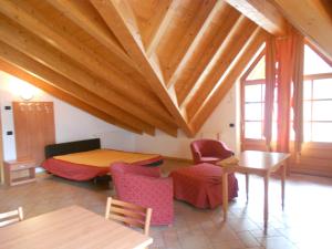sala de estar con mesa, sillas y techo de madera. en Residence Le Orchidee en Bormio