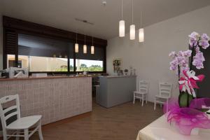 a kitchen and dining room with a counter and chairs at Podere San Luigi Residence in Otranto