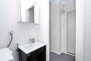 ヘルシンキにある2ndhomes Lönnrotinkatu Apartmentの白いバスルーム(シンク、鏡付)