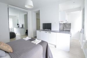 ヘルシンキにある2ndhomes Lönnrotinkatu Apartmentの白い部屋(ベッド1台、キッチン付)