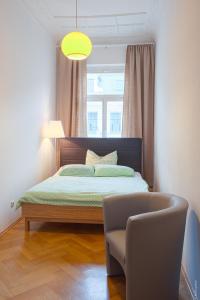 ライプツィヒにあるStudio Waldstraßenviertelのベッドルーム1室(ベッド1台、椅子、窓付)