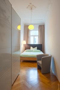 ライプツィヒにあるStudio Waldstraßenviertelのベッドルーム1室(ベッド1台、椅子、鏡付)