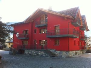 um edifício vermelho com escadas em frente em Residence Le Orchidee em Bormio