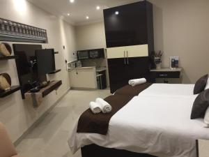 een slaapkamer met een groot bed en handdoeken bij Villa MikaMora in Johannesburg