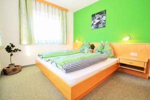 a bedroom with a bed with a green wall at Gasthof Pension Hetzenbichl in Sankt Johann im Pongau